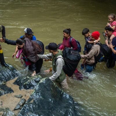 Migrantes atravessam rio na selva de Darién