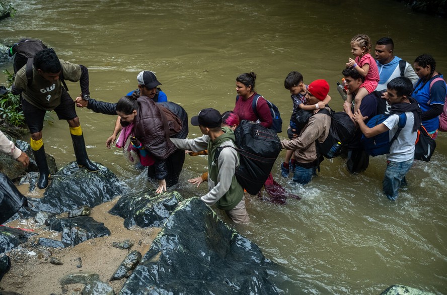 Migrantes atravessam rio na selva de Darién