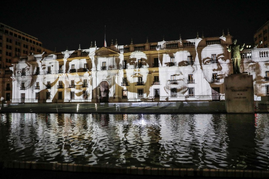 Imagens de presos políticos desaparecidos durante a ditadura militar chilena são projetadas na fachada do Palácio de La Moneda