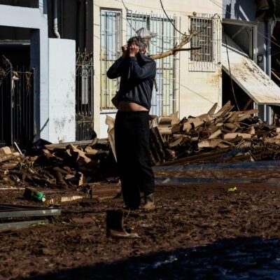 Um morador chora ao ver os estragos em sua casa em uma rua coberta de lama e detritos após passagem de um ciclone em Muçum, Rio Grande do Sul