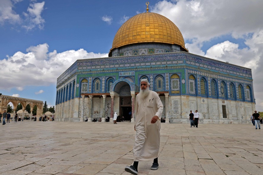 Homem palestino caminha em frente à mesquita de al-Aqsa, em Jerusalém