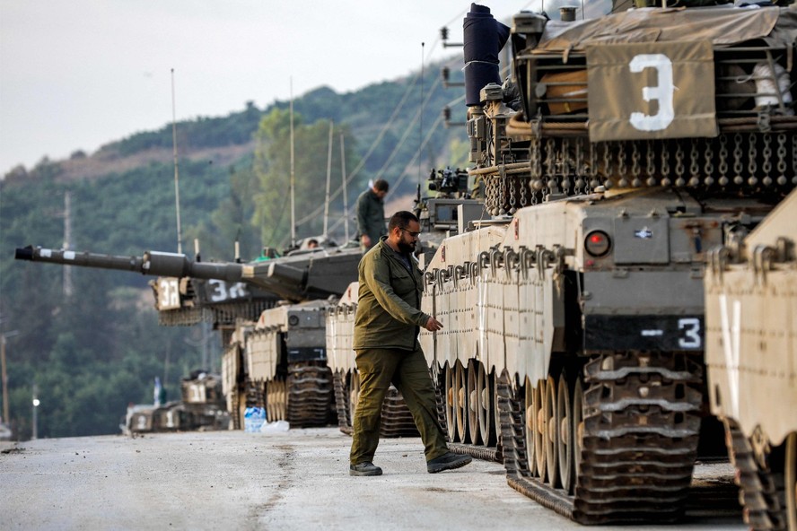 Soldado israelense passa por tanque de guerra na alta Galileia, no norte de Israel, perto da fronteira com o Líbano