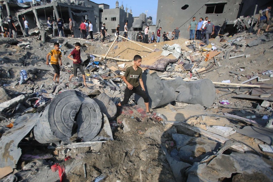 Palestinos procuram sobreviventes nos escombros de prédios bombardeados por Israel em Jabaliya, no norte da Faixa de Gaza