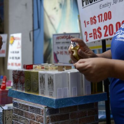 Vendedora entrega fragrâncias aos pedestres em loja na tradicional área de compras do Saara, no centro do Rio de Janeiro