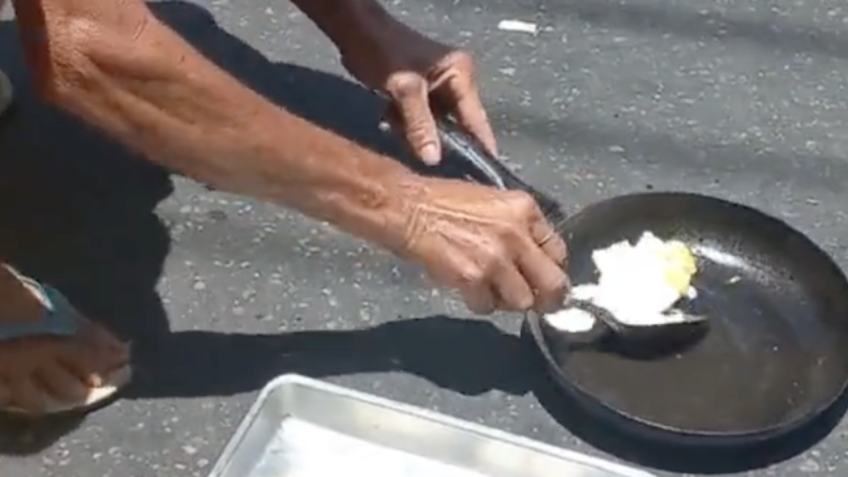 Homem frita ovo com o calor do asfalto em Duque de Caxias, município do Rio de Janeiro