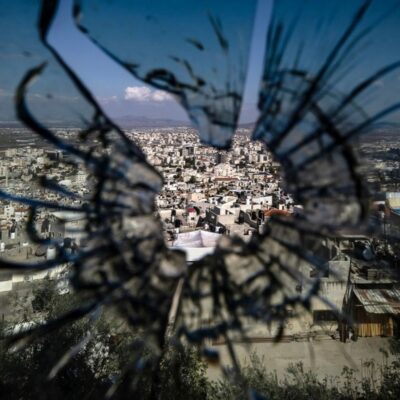 Foto tirada através do buraco de uma bala em uma janela mostra a vista da cidade de Jenin, na Cisjordânia ocupada por Israel