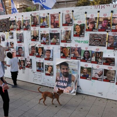 People look at an installation which shows the pictures of hostages taken by Palestinian Islamist group Hamas following a deadly infiltration of Israel by Hamas gunmen from the Gaza Strip on October 7, before some of them are due to be released as part of a deal between Israel and Hamas to free hostages held in Gaza in exchange for the release of Palestinian prisoners, in Tel Aviv, Israel, November 24, 2023. REUTERS/Ronen Zvulun