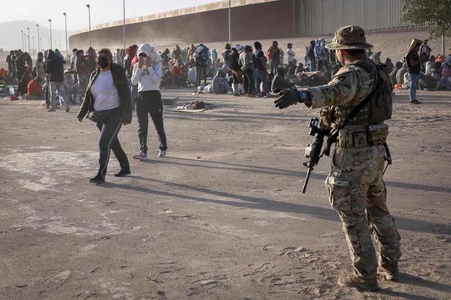 Soldado da Guarda Nacional do Texas direciona imigrantes que cruzaram a fronteira dos EUA