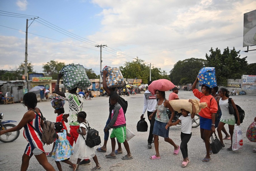Pessoas fogem de violência em no bairro de Petion-ville, em Porto Príncipe, em 30 de janeiro de 2024
