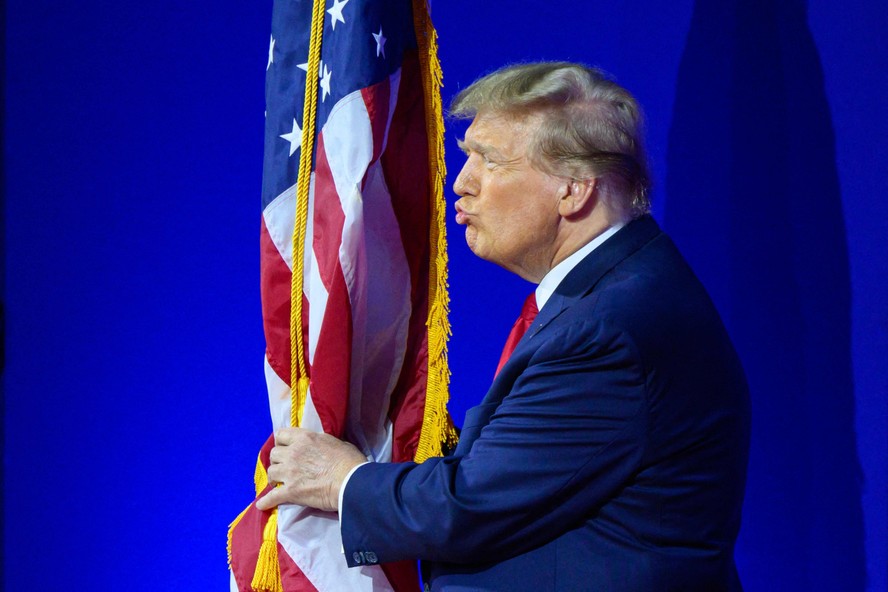 Trump beija a bandeira dos EUA durante reunião anual da Conferência de Ação Política Conservadora  em National Harbor, Maryland