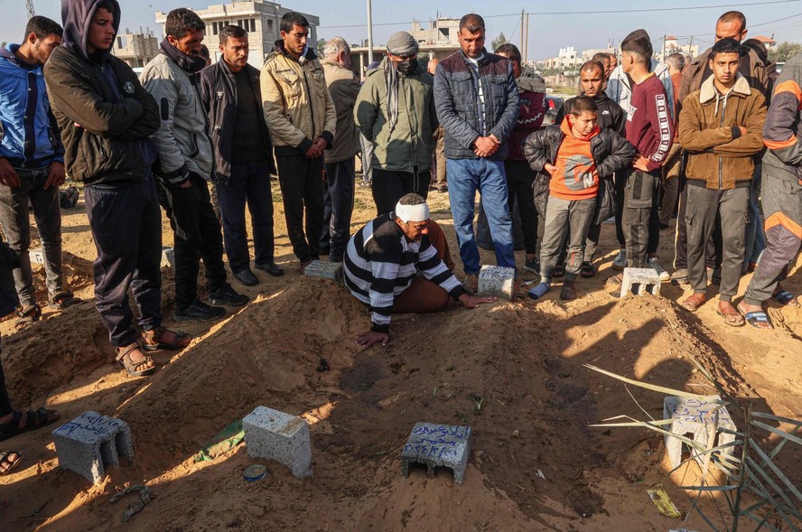 Palestinos enterram seus mortos após ataques aéreos israelenses durante a noite, em um cemitério no leste de Khan Yunis, no sul da Faixa de Gaza