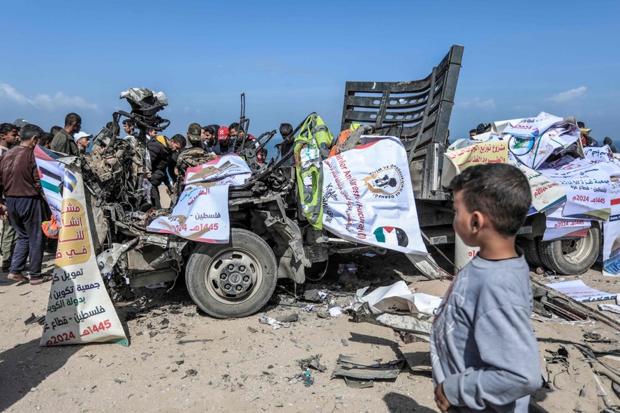 Pessoas se reúnem em torno de caminhão que transportava ajuda humanitária, mas foi atingido por ataque aéreo israelense em Deir el-Balah, no centro de Gaza