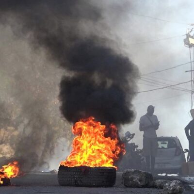 Pneus em chamas perto da principal prisão de Porto Príncipe, após a fuga de milhares de presidiários