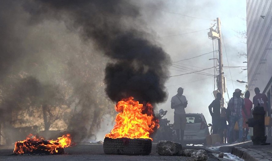 Pneus em chamas perto da principal prisão de Porto Príncipe, após a fuga de milhares de presidiários