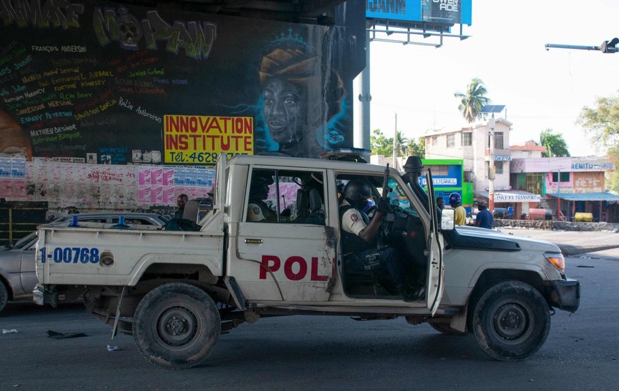 Policiais controlam o perímetro da delegacia de polícia incendiada no dia anterior por gangues armadas, em Porto Príncipe, Haiti
