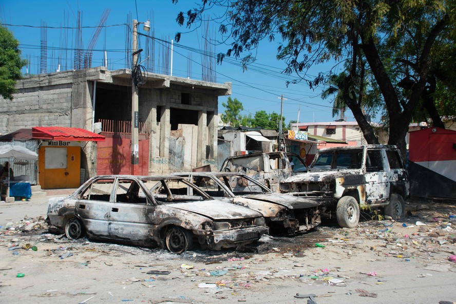 Veículos carbonizados permanecem estacionados enquanto a violência das gangues aumenta em Porto Príncipe, Haiti.