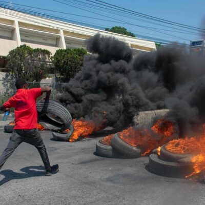 Homem queima pneus em rua de Porto Príncipe após anúncio da renúncia do premier haitiano Ariel Henry