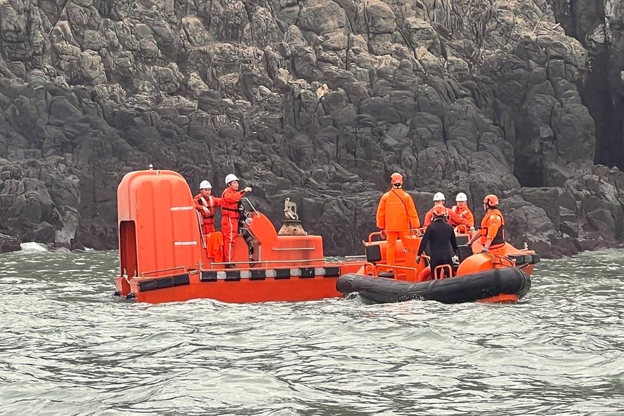Funcionários da Guarda Costeira chinesa (capacetes brancos) e membros da Guarda Costeira de Taiwan (capacetes laranja) fazem buscas por pescadores desaparecidos nas águas da ilha Dongding