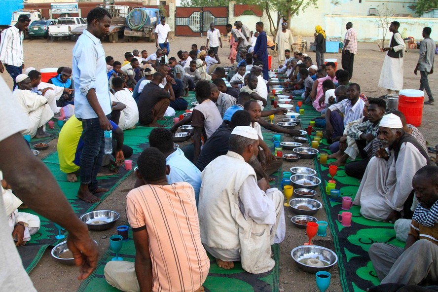 Muçulmanos deslocados esperam para quebrar jejum em pátio durante mês sagrado islâmico do Ramadã em Gedaref, no Sudão