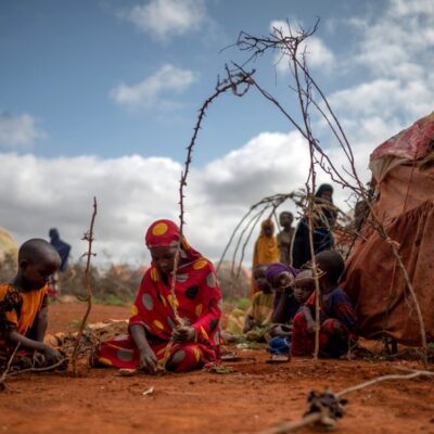 Menina e sua sobrinha construindo uma tenda com galhos em Baidoa, na Somália, onde dezenas de milhares de pessoas se deslocaram para fugir da fome e da seca