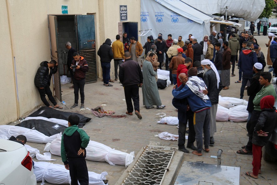 Cadáveres são amontoados após bombardeio israelense na Faixa de Gaza, no sábado