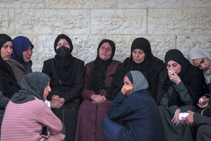 Mulheres choram após a morte de 36 pessoas da mesma família em Gaza, neste sábado