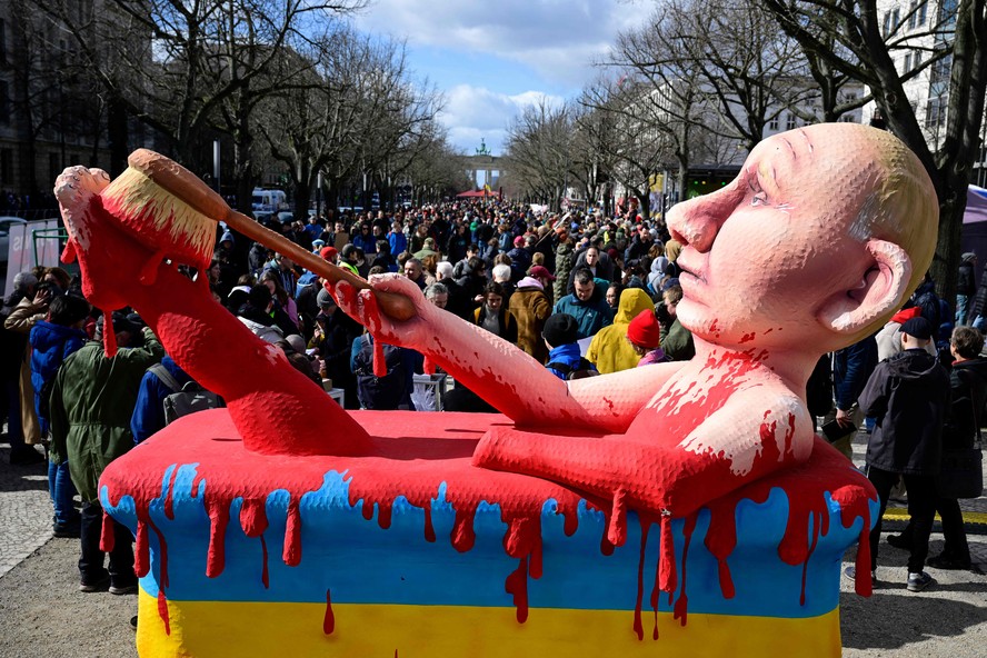 Boneco do presidente russo, Vladimir Putin, em uma banheira de sangue é vista durante comício em frente à embaixada russa em Berlim, onde eleitores fizeram fila para votar nas eleições presidenciais russas de 17 de março de 2024.