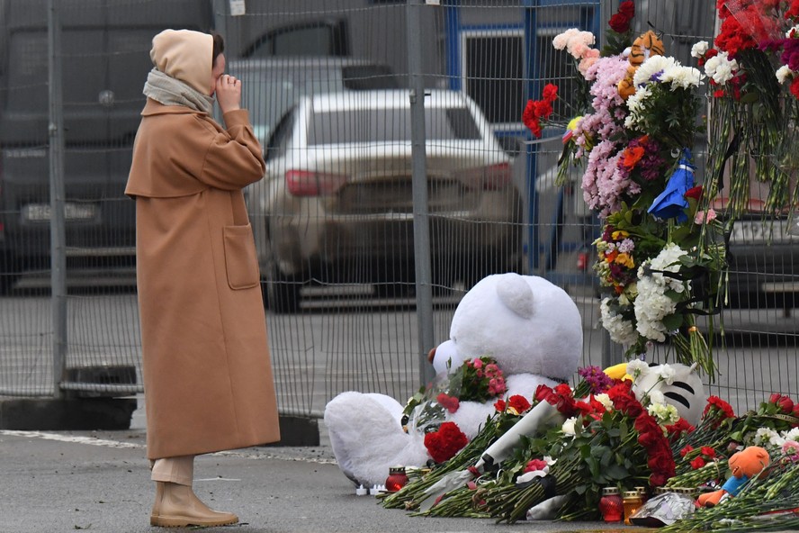 Russos fazem memorial a vítimas de atentado terrorista em frente a centro comercial atacado