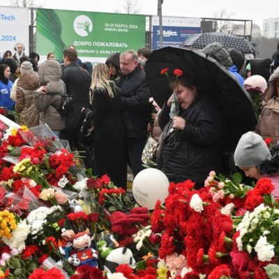 Pessoas depositam flores em um memorial improvisado em frente à prefeitura de Crocus, em Krasnogorsk
