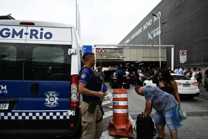 Pessoas são evacuadas do lado de fora do terminal de ônibus Novo Rio depois que um homem armado mantém passageiros como reféns no Rio de Janeiro.  -  (crédito: Pablo PORCIUNCULA / AFP)