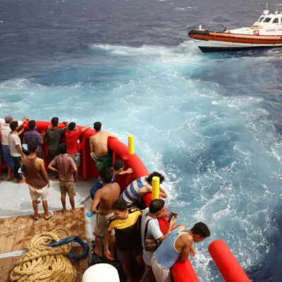 .Pessoas a bordo do barco de resgate da ONG Proactiva Open Arms Uno olham para o barco da guarda costeira indo para a ilha de Lampedusa, no mar Mediterrâneo central, Itália.
19/08/2022
REUTERS/Juan Medina/Foto de arquivo