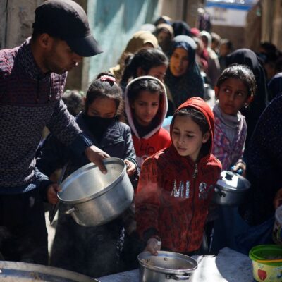 CRIANÇAS FOME GAZA - Palestinian children wait to receive food cooked by a charity kitchen amid shortages of food supplies, as the ongoing conflict between Israel and the Palestinian Islamist group Hamas continues, in Rafah, in the southern Gaza Strip, March 5, 2024. REUTERS/Mohammed Salem