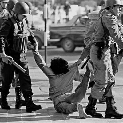 Guardas da polícia federal detêm homem durante marcha contra a ditadura em Buenos Aires em março de 1982