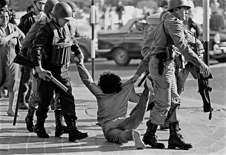 Guardas da polícia federal detêm homem durante marcha contra a ditadura em Buenos Aires em março de 1982