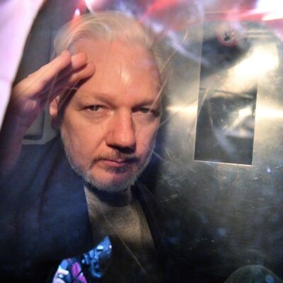 O fundador do WikiLeaks, Julian Assange, gesticula da janela de uma van da prisão enquanto é expulso do Southwark Crown Court, em Londres, em maio de 2019, após ter sido condenado a 50 semanas de prisão por violar suas condições de fiança em 2012.