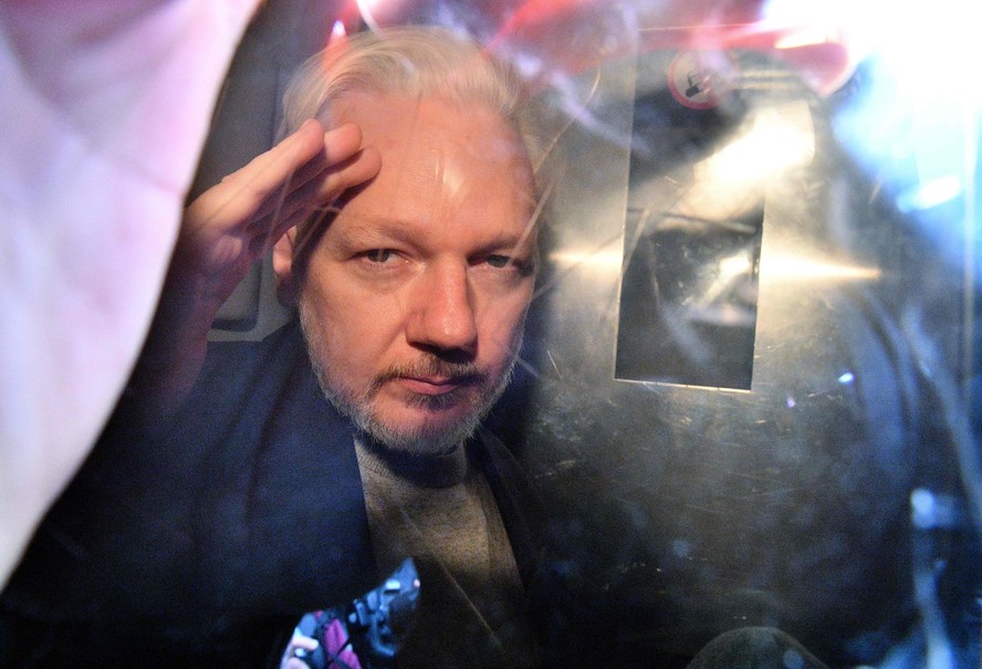 O fundador do WikiLeaks, Julian Assange, gesticula da janela de uma van da prisão enquanto é expulso do Southwark Crown Court, em Londres, em maio de 2019, após ter sido condenado a 50 semanas de prisão por violar suas condições de fiança em 2012.