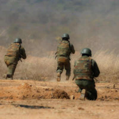Militares fardados e armados em simulação de operação na mata
