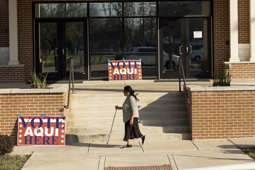 Eleitora caminha em frente a local de votação no Texas durante a Super Terça