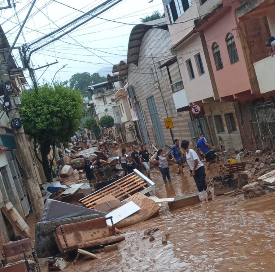 Moradores da Vila do Sul, em Alegre, no Espírito Santo, recolhem entulho deixado pela enchente