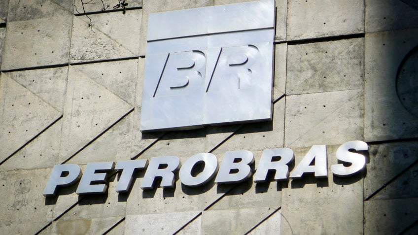Fachada da Petrobras, com logo em metal prateado sobre parede cinzenta de concreto