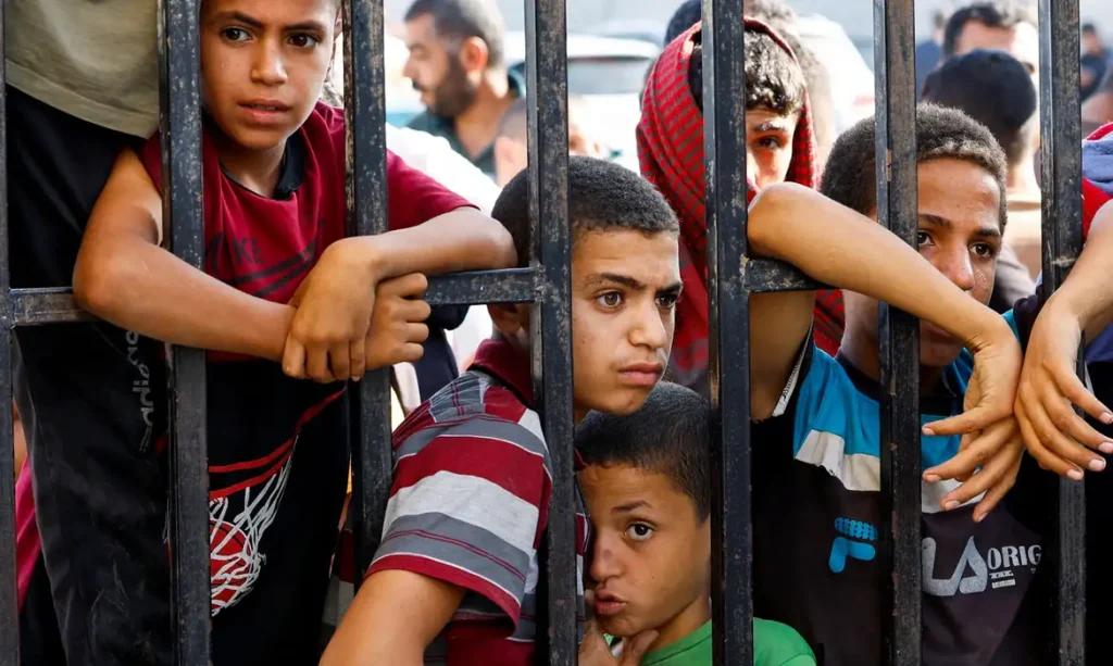 Children wait for the arrival of Palestinian workers, who were in Israel during the Hamas October 7 attack, at the Rafah border after being sent back by Israel to the strip, in the southern Gaza Strip, November 3, 2023. REUTERS/Ibraheem Abu Mustafa     TPX IMAGES OF THE DAY