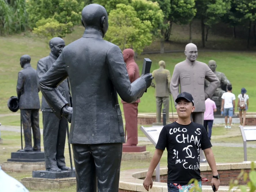 Turista passa por estátuas de Chiang Kai-shek em parque dedicado ao ditador na cidade de Taoyuan, no norte de Taiwan