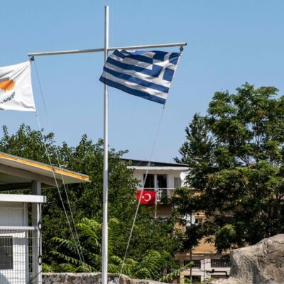 Bandeiras do Chipre, da Grécia e da Turquia na Linha Verde: ilha foi dividida em 1974, quando a parte norte foi invadida por tropas turcas