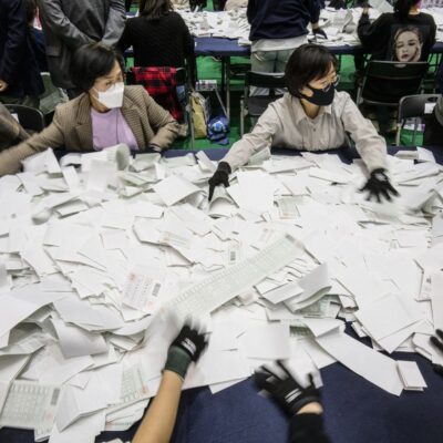 Funcionários eleitorais separam as cédulas em uma estação de contagem em Seul, em 10 de abril de 2024, após o encerramento da votação nas eleições parlamentares.