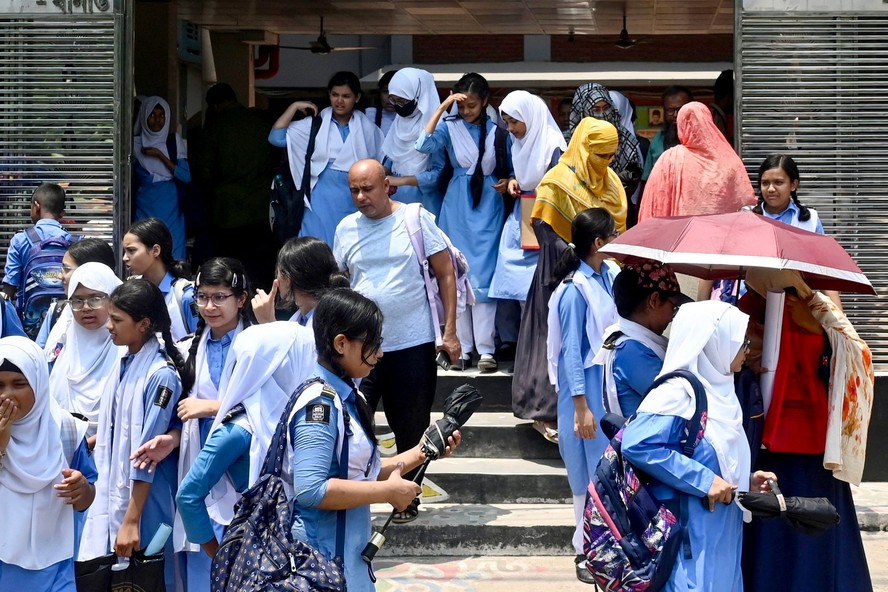 Alunos chegam para a aula em uma escola em Daca, em meio à onda de calor no Sudeste Asiático