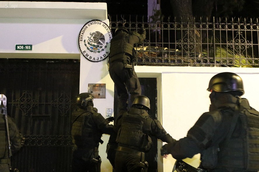 Um dos policias da Força especial equatoriana escala o muro da embaixada do México, em Quito, para prender o ex-vice-presidente do Equador, Jorge Glas