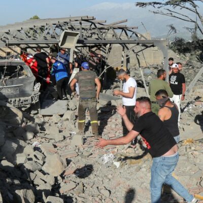 Socorristas escavam os escombros de um prédio após um bombardeiro israelense atingir uma casa na cidade libanesa de Marjayoun
