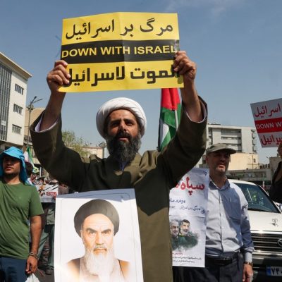 Clérigo muçulmano levanta um cartaz durante uma manifestação anti-Israel em Teerã