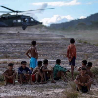 Indígenas observam helicóptero da FAB pousar em Surucucu, na Terra Indígena Yanomami em Roraima