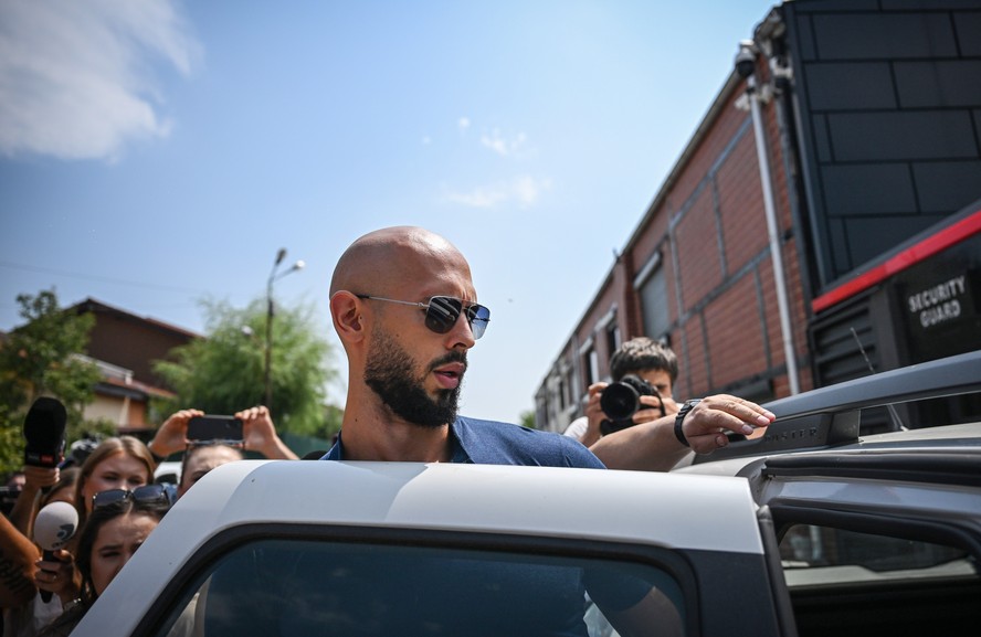 O influenciador Andrew Tate após falar com a mídia em frente à sua casa, em Bucareste